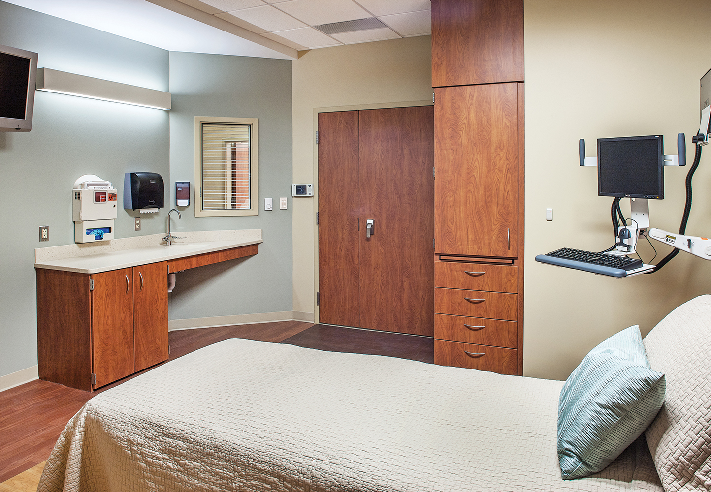 Linear Art Sconce as patient room lighting, mounted horizontally on a light green wall above a sink area.