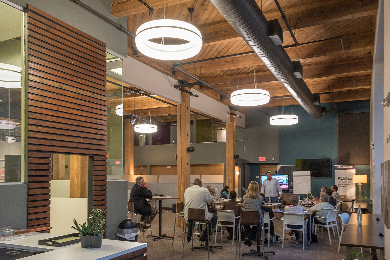 Meridian Round pendant is perfect for hospitality lighting, seen here above a casual café area in a large office building.