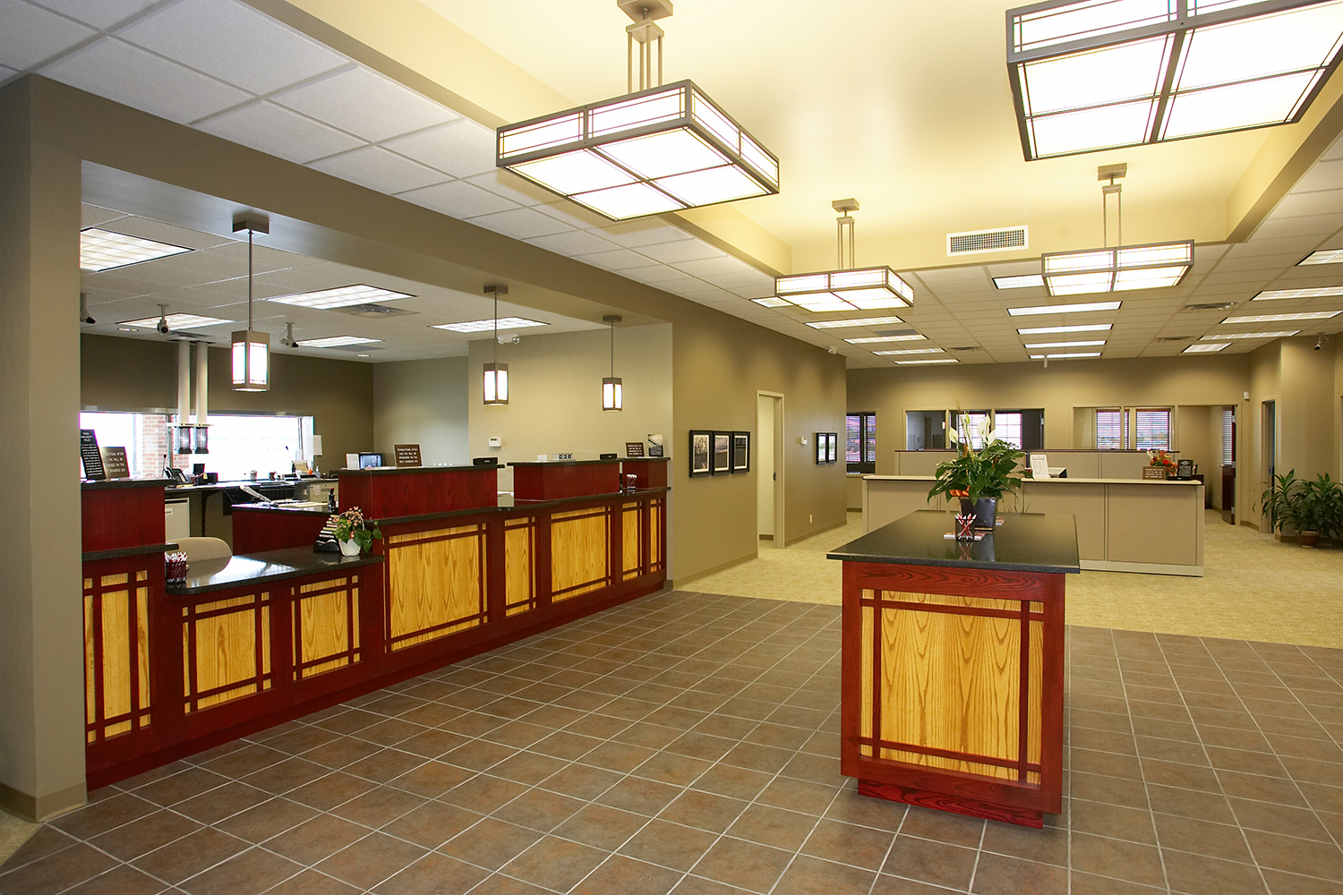 Midland Crafts architectural lighting fixtures illuminate a sophisticated bank lobby.