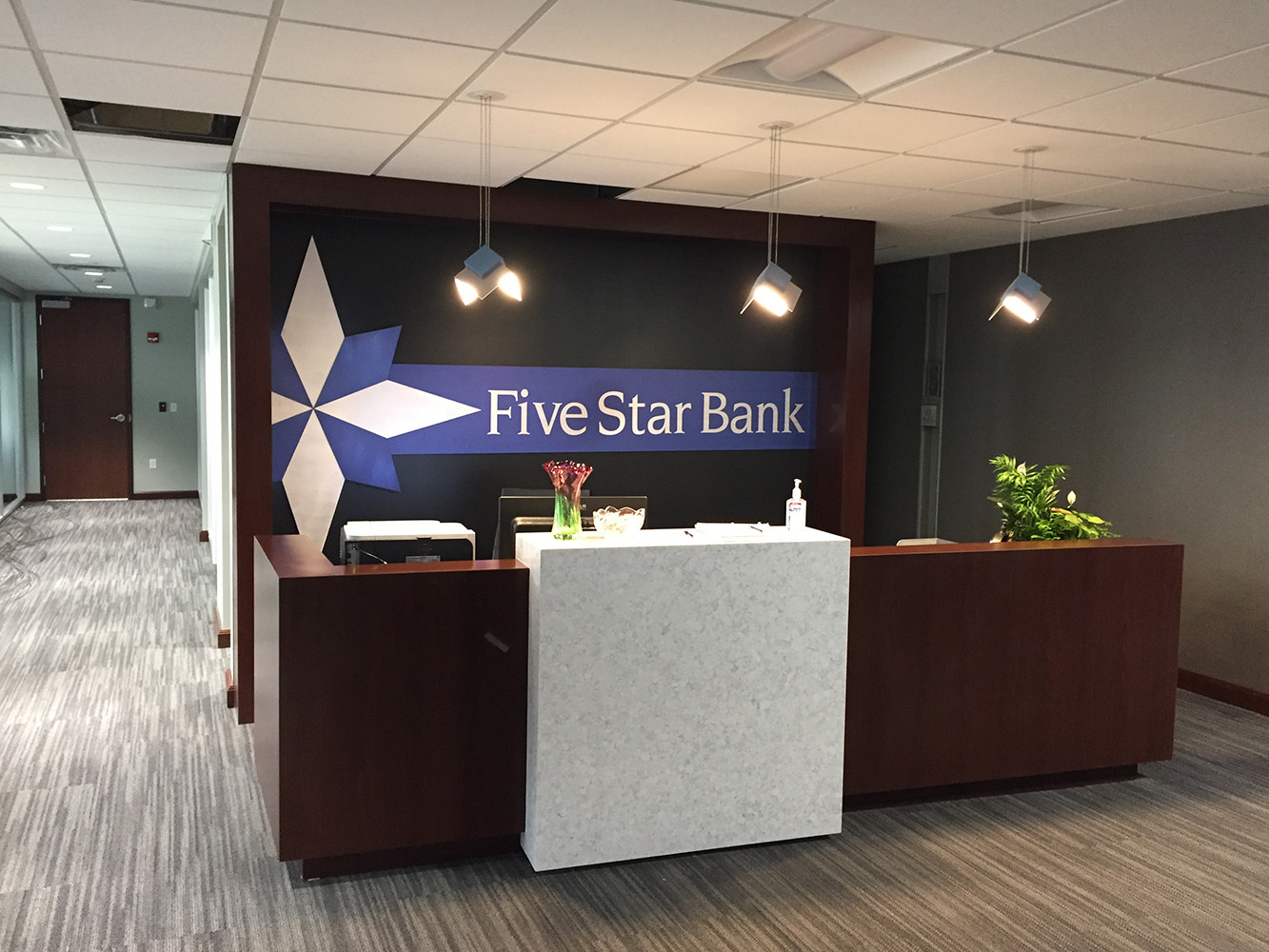 Petal OLED pendants provide distinctive architectural lighting above a bank lobby reception desk.