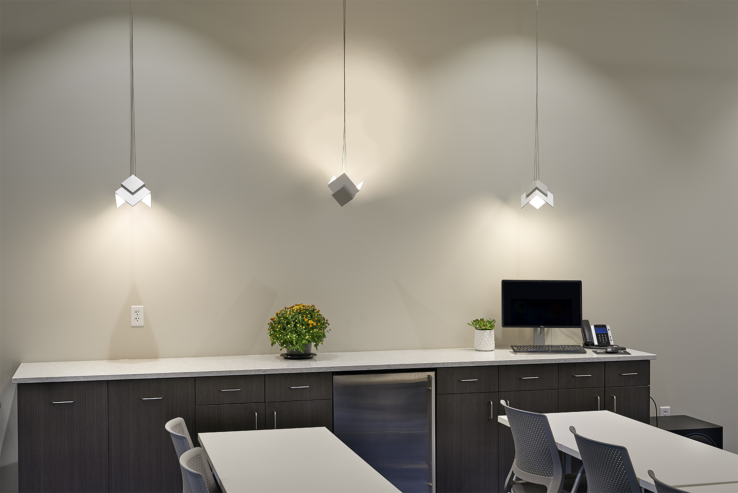 Petal OLED pendants are in an office lighting application along a meeting room wall.