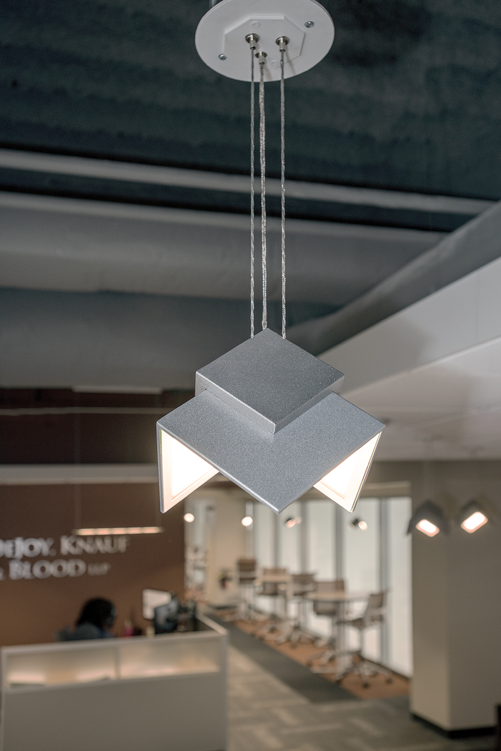 Petal OLED pendants are eye-catching office lighting fixtures, seen here above a workplace reception area.