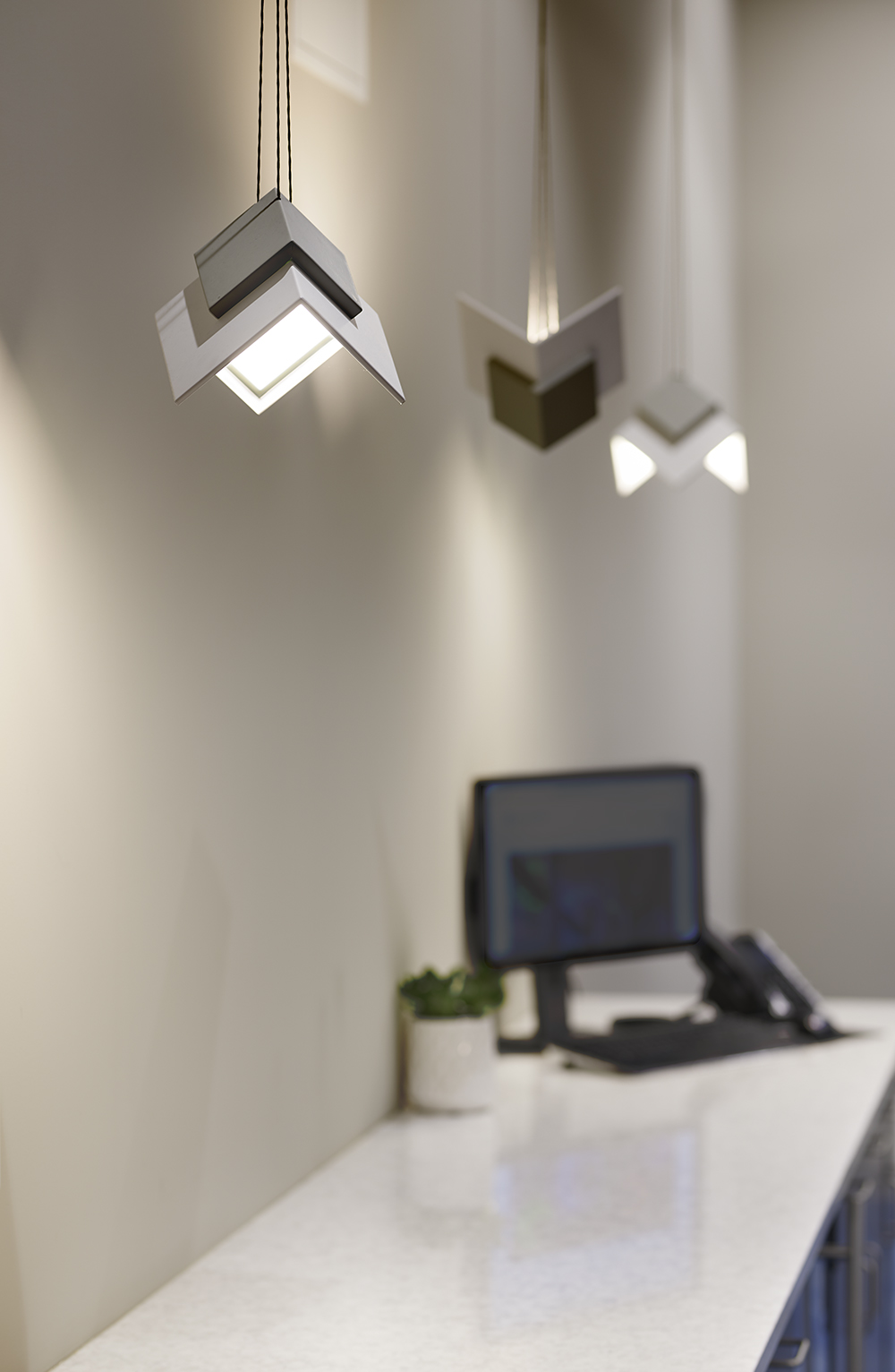 Petal OLED pendants as office lighting fixtures along a meeting room wall.