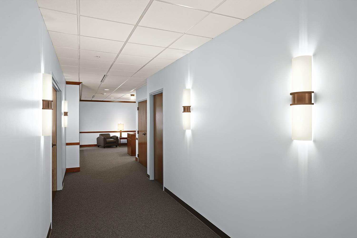 Pila sconces make stylish office lighting fixtures along a workplace corridor.