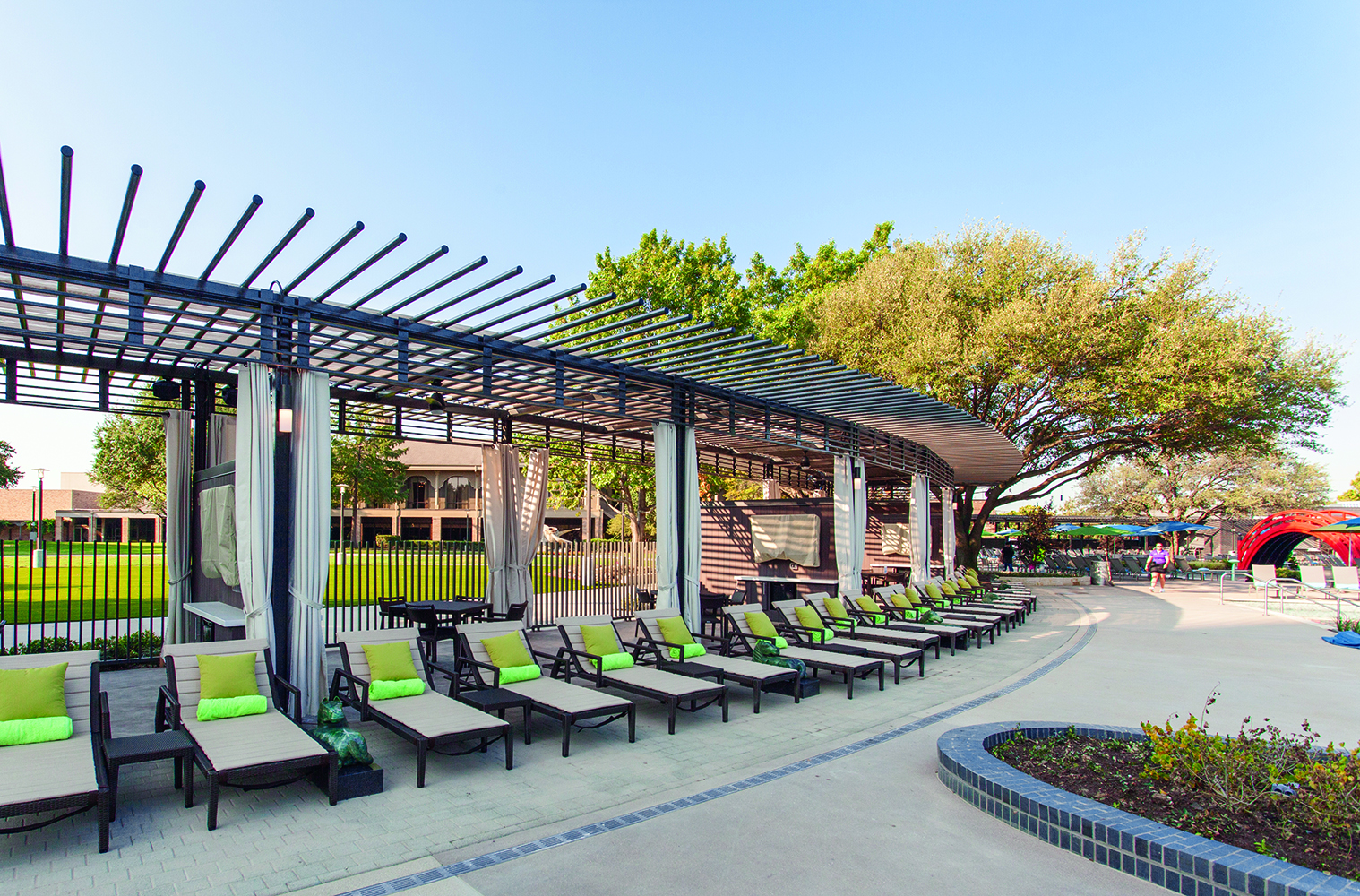 Scope modern lighting fixtures illuminate a poolside pergola structure.