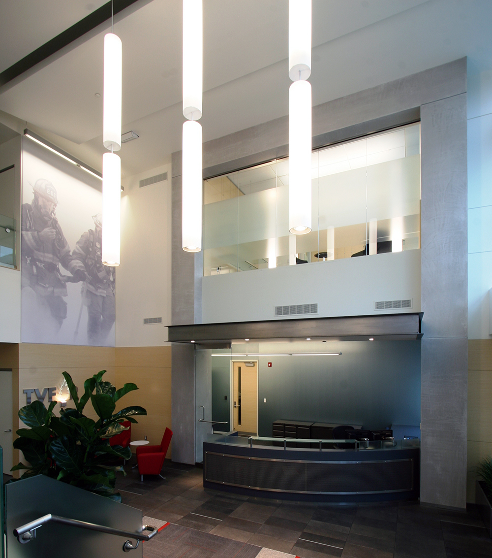 Sequence architectural lighting fixtures illuminate a fire department lobby and reception area.