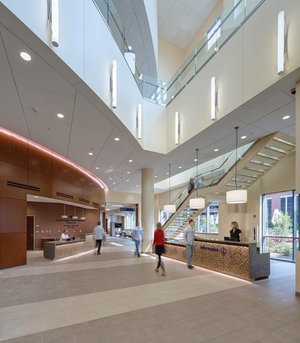 Sequence luminous tube sconce in a medical lighting design, mounted on the open second floor wall of a clinic lobby.