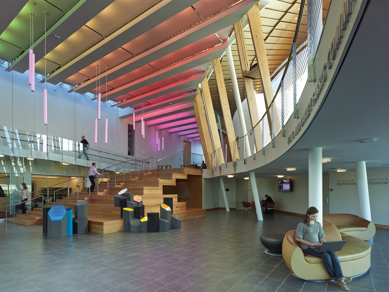 Sequence modern lighting fixtures illuminate a colorful open staircase with purpose light.