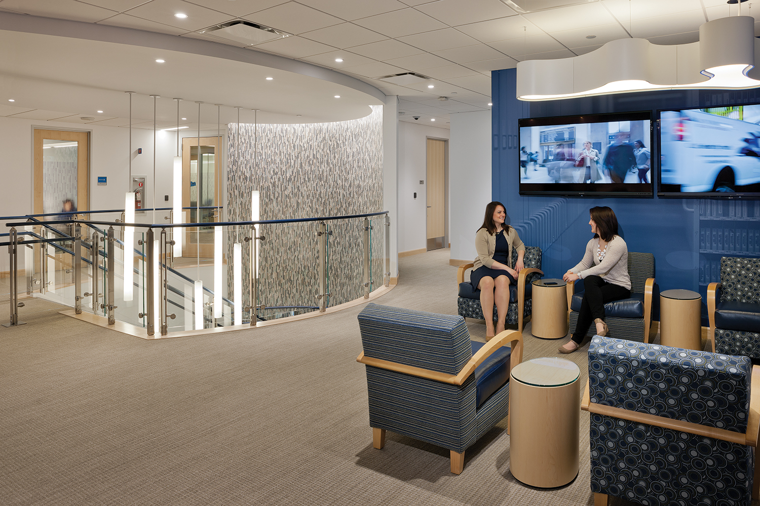 Sequence office lighting fixtures illuminate a modern staircase in a sleek multi-level office building.