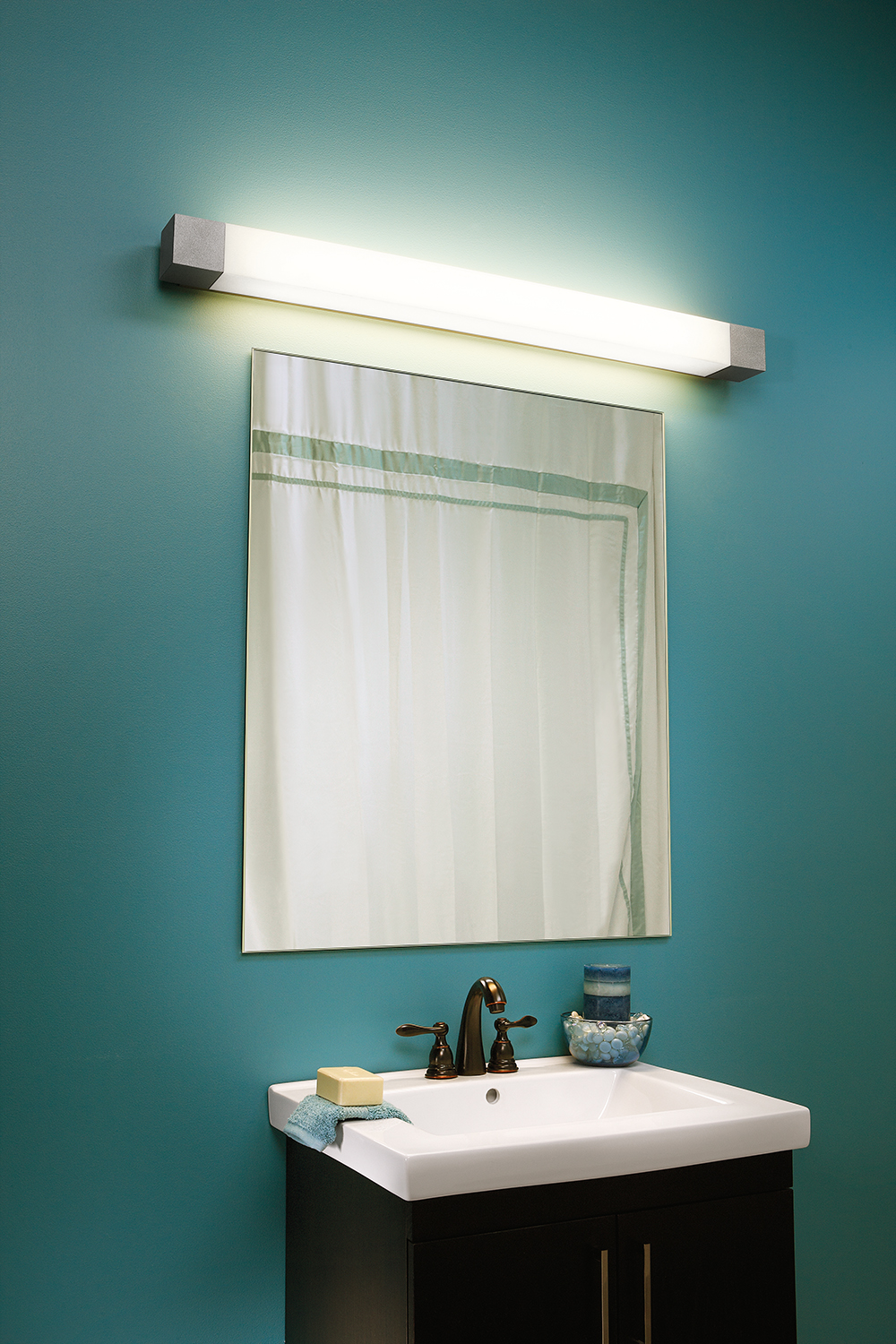 Shine modern vanity light fixture mounted horizontally over a minimalist mirror and vanity for multifamily residential design.