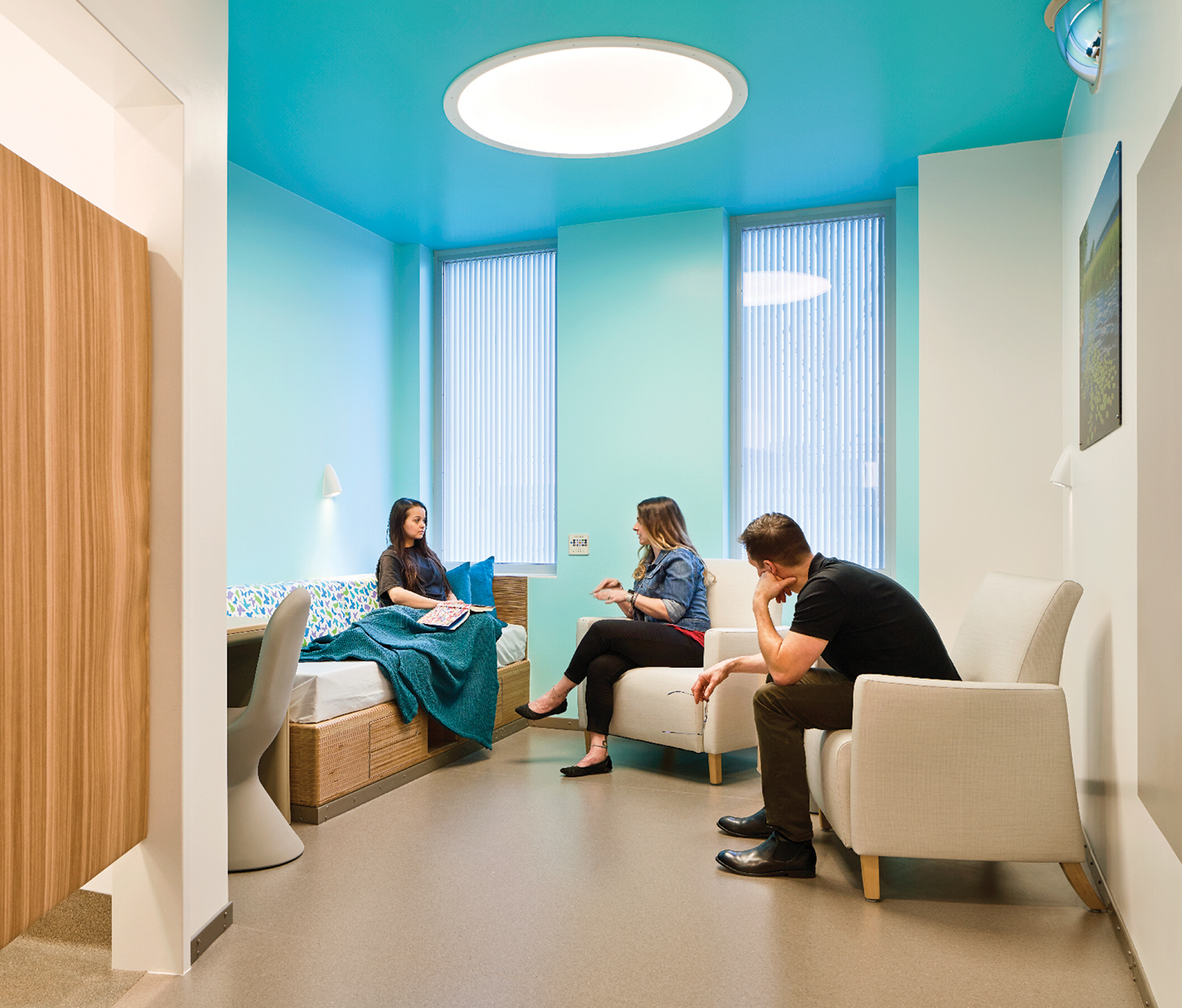 A behavioral health patient bedroom with the Symmetry ceiling light and Gig wall sconce.