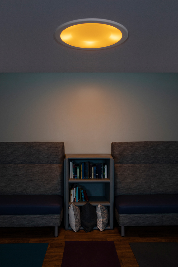 Symmetry behavioral health ceiling luminaire in nightlight mode over a yoga room