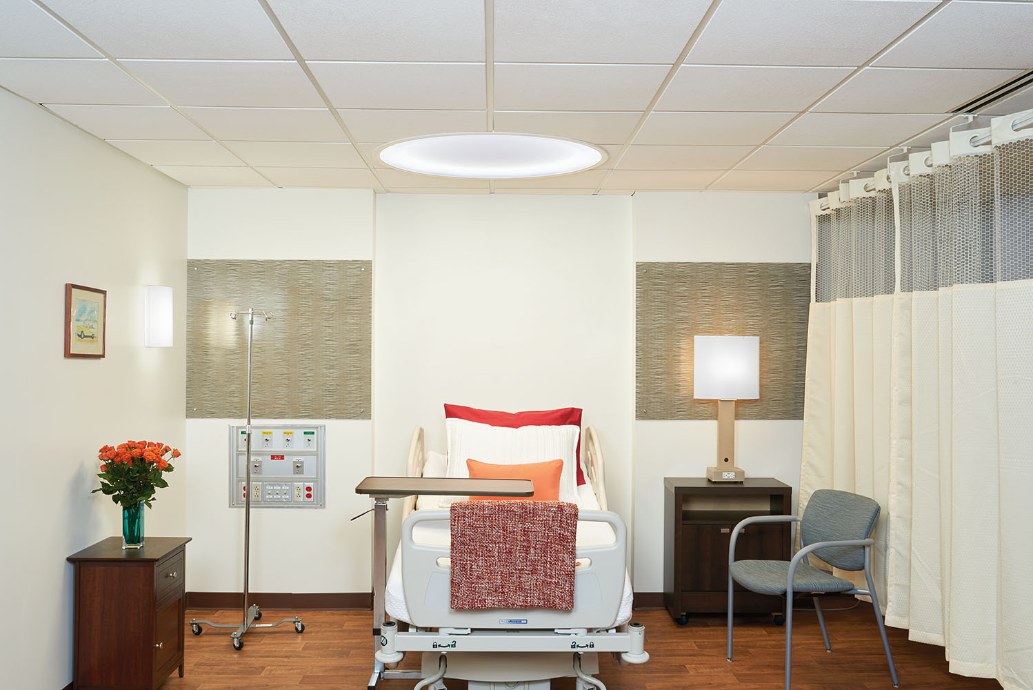 Symmetry overbed and Serenity table lamp fixtures provide comforting patient room lighting.