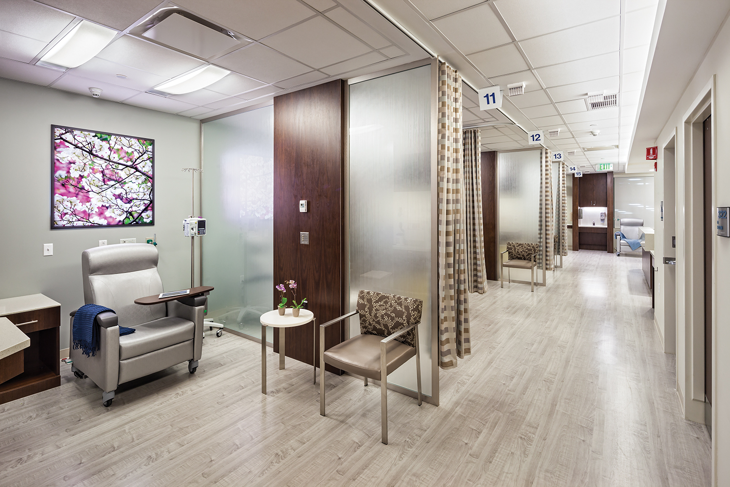 Unity patient room lighting illuminates an infusion station in an open treatment corridor.