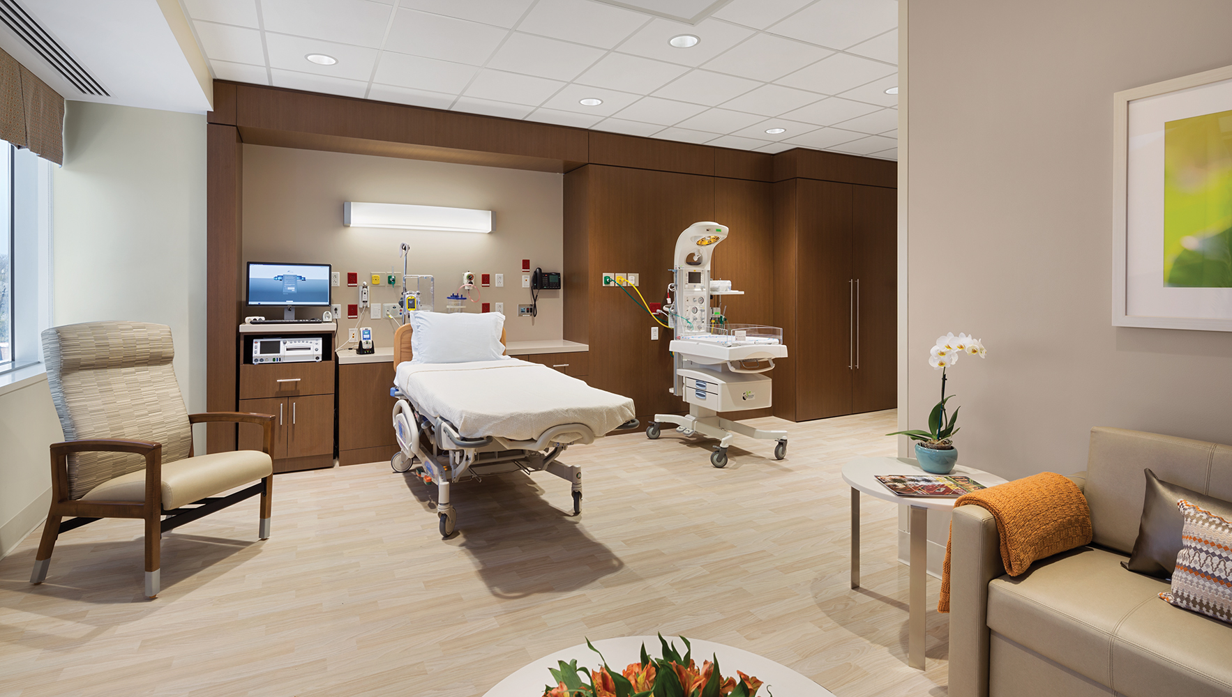 Unity headwall luminaire provides beautiful illumination for a large patient room lighting design with a seating area.