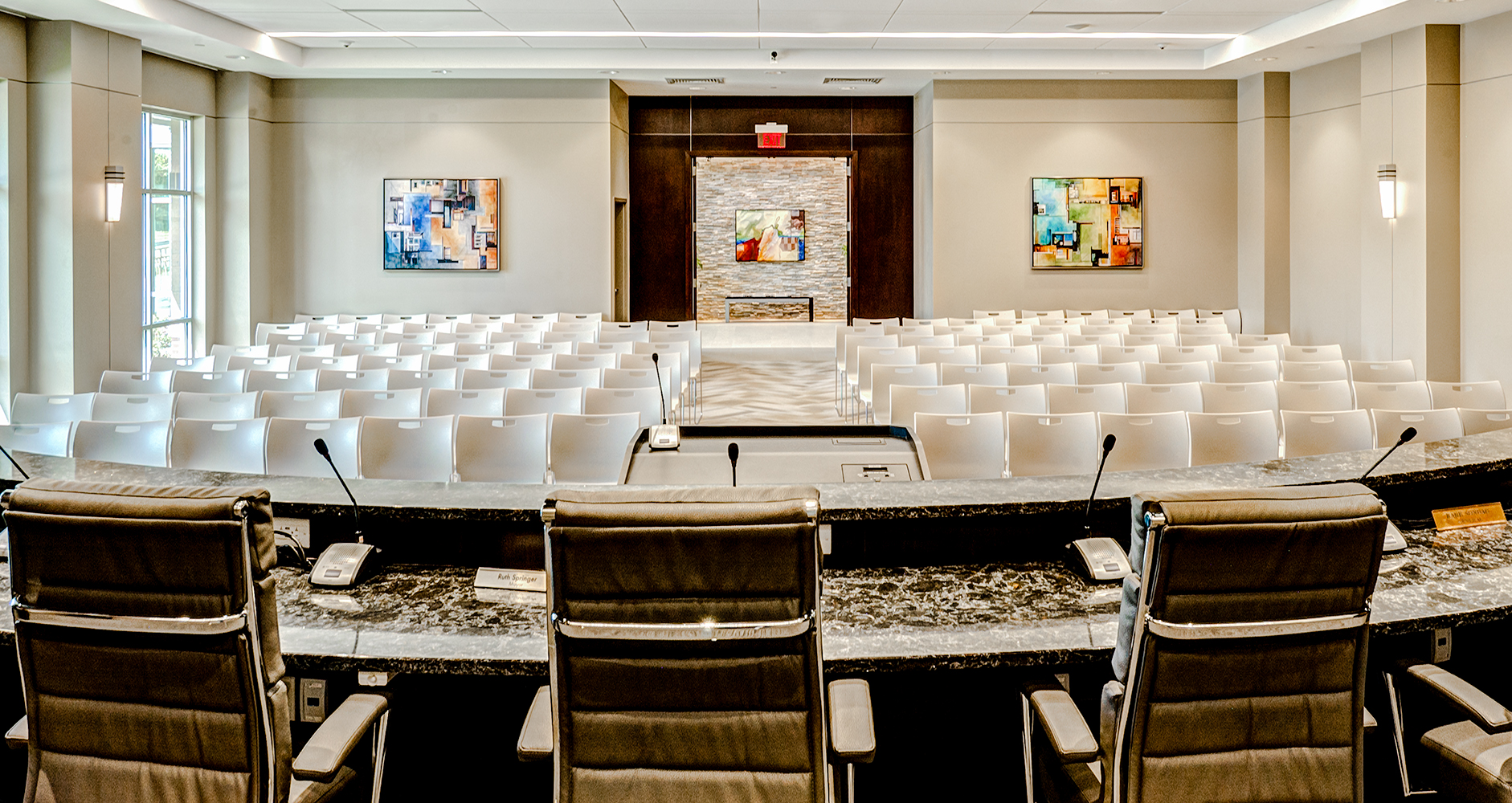 Wedge sconces provide sophisticated architectural lighting for a modern government meeting room 