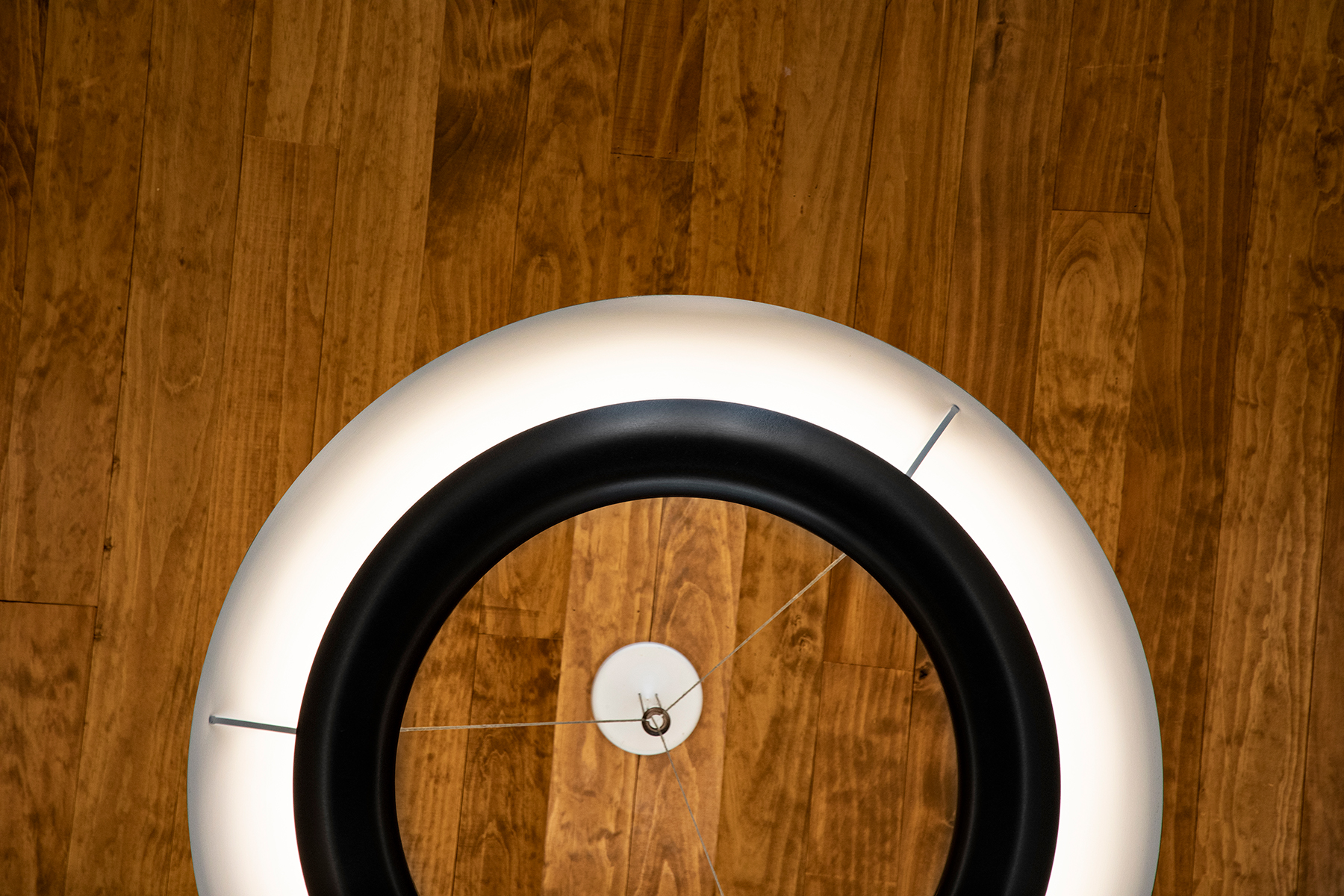 Close-up shot of the Cosmo ring pendant from underneath, with a natural wood ceiling