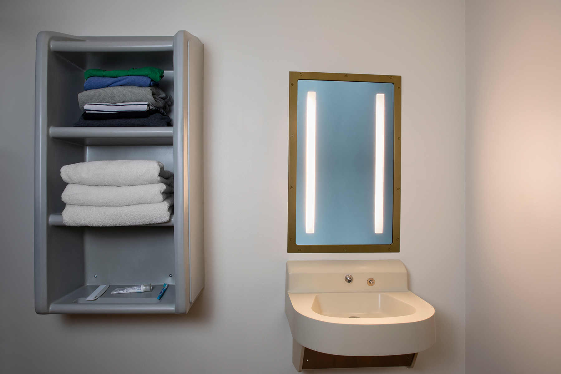 Sole rectangular illuminated mirror in a behavioral health bathroom