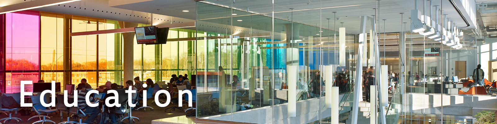 Computer lab with colorful windows and an atrium with Sequence pendants suspended